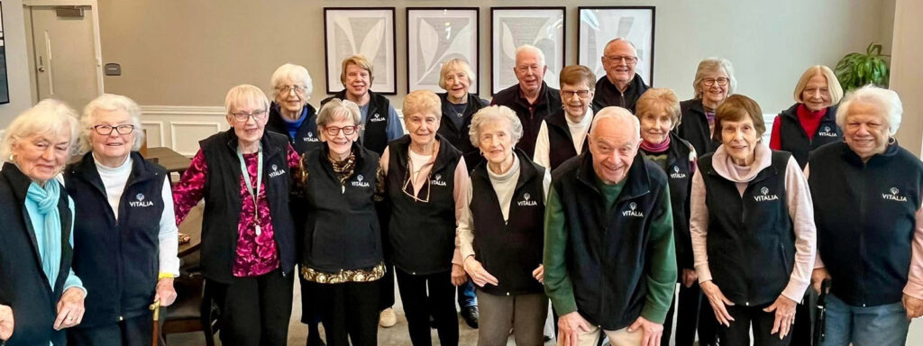 Radiating happiness, a lovely group of seniors proudly display their Vitalia vests while posing for a heartwarming photograph.